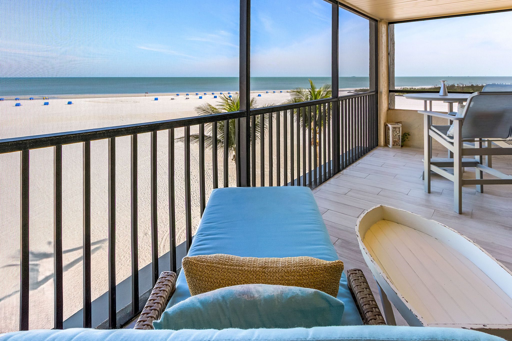 Oceanfront condo porch with cozy lounge chair overlooking Fort Myers Beach and the Gulf of Mexico—perfect for enjoying Southwest Florida coastal living