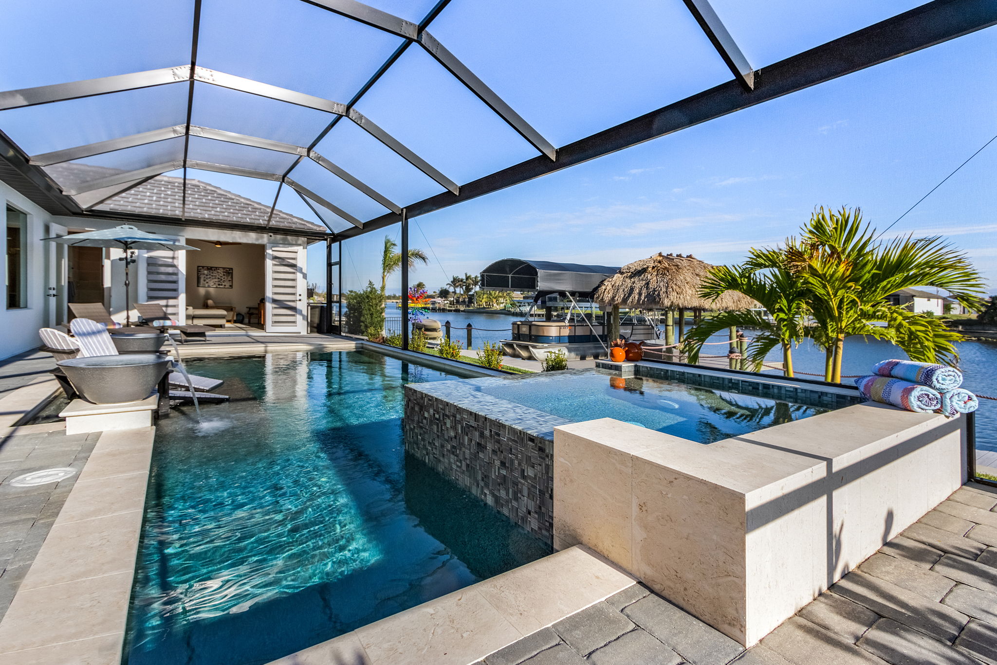 Southwest Florida outdoor living space featuring pool, jacuzzi, and screened lanai—perfect for resort-style homebuyers seeking luxury real estate