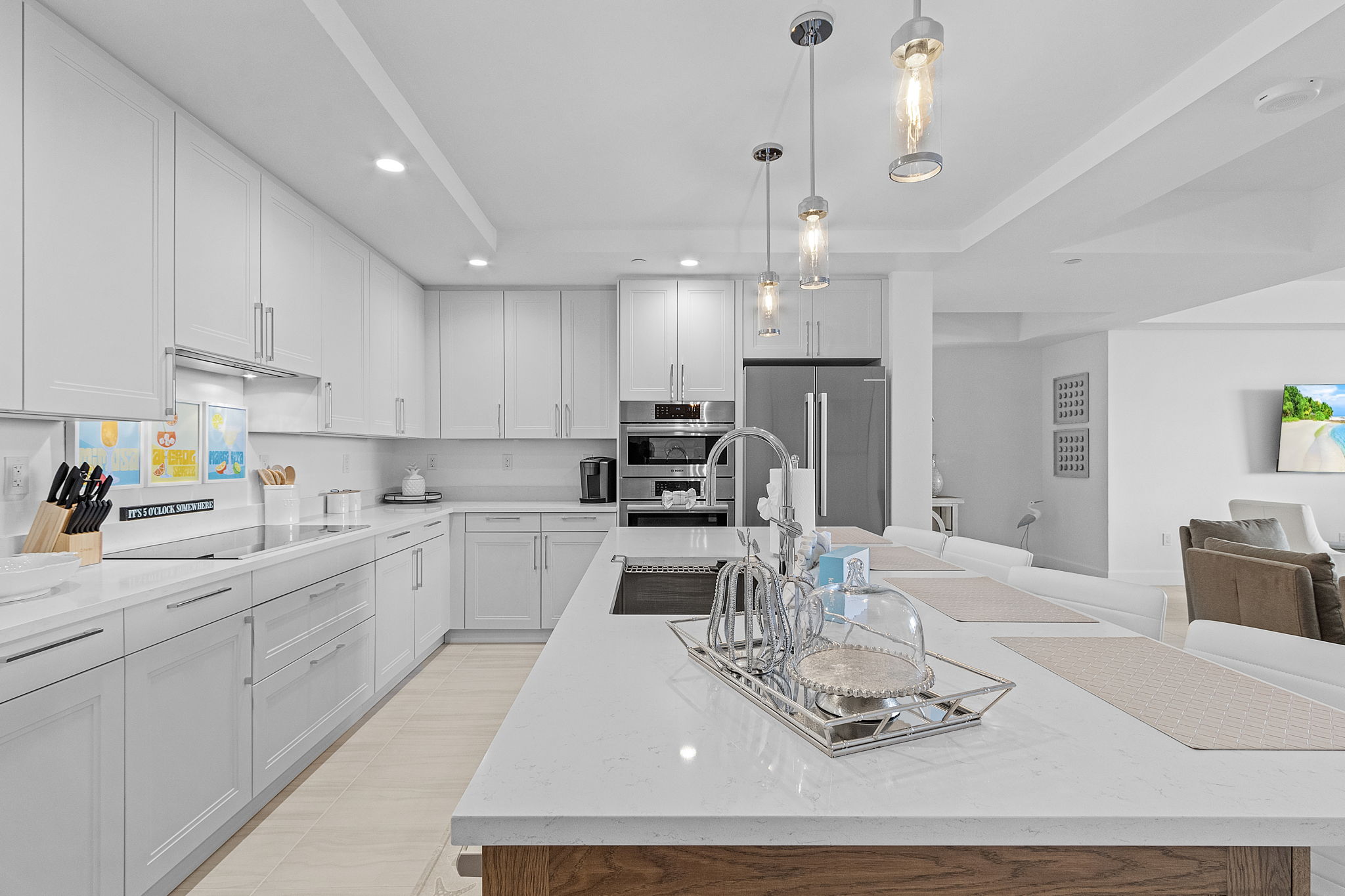 Bright white luxury kitchen with clean tile finishes and open coastal layout—highlighting Southwest Florida’s modern beach home style