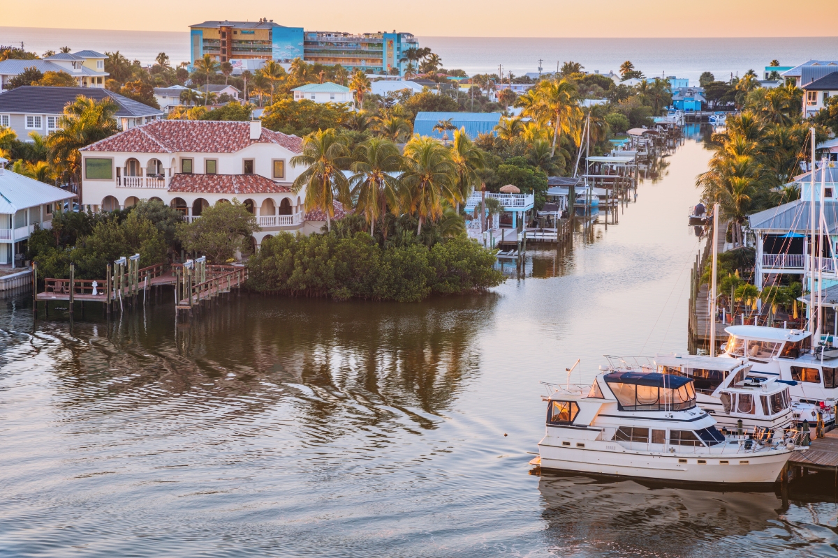 Stunning sunset over Fort Myers Beach canals with boats—showcasing Southwest Florida’s boating lifestyle and laid-back coastal living